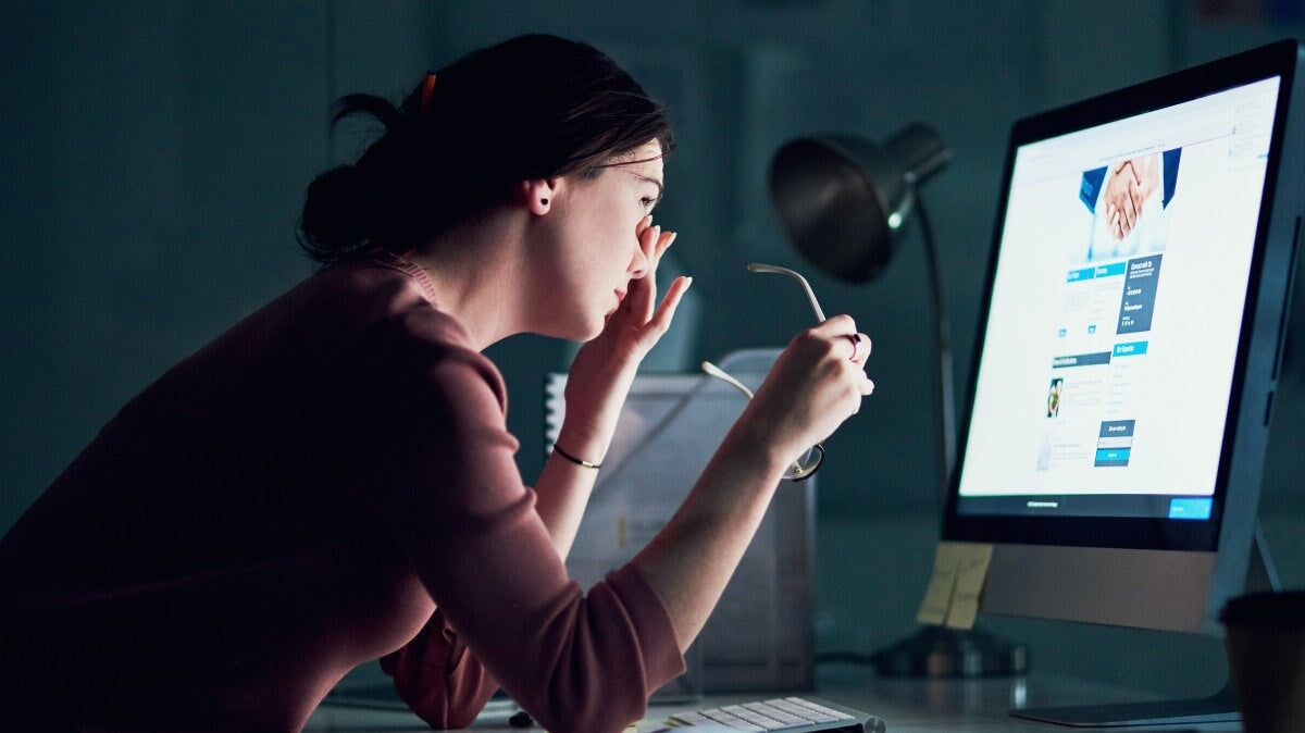 une femme devant son écran qui travaille tard a une fatigue oculaire