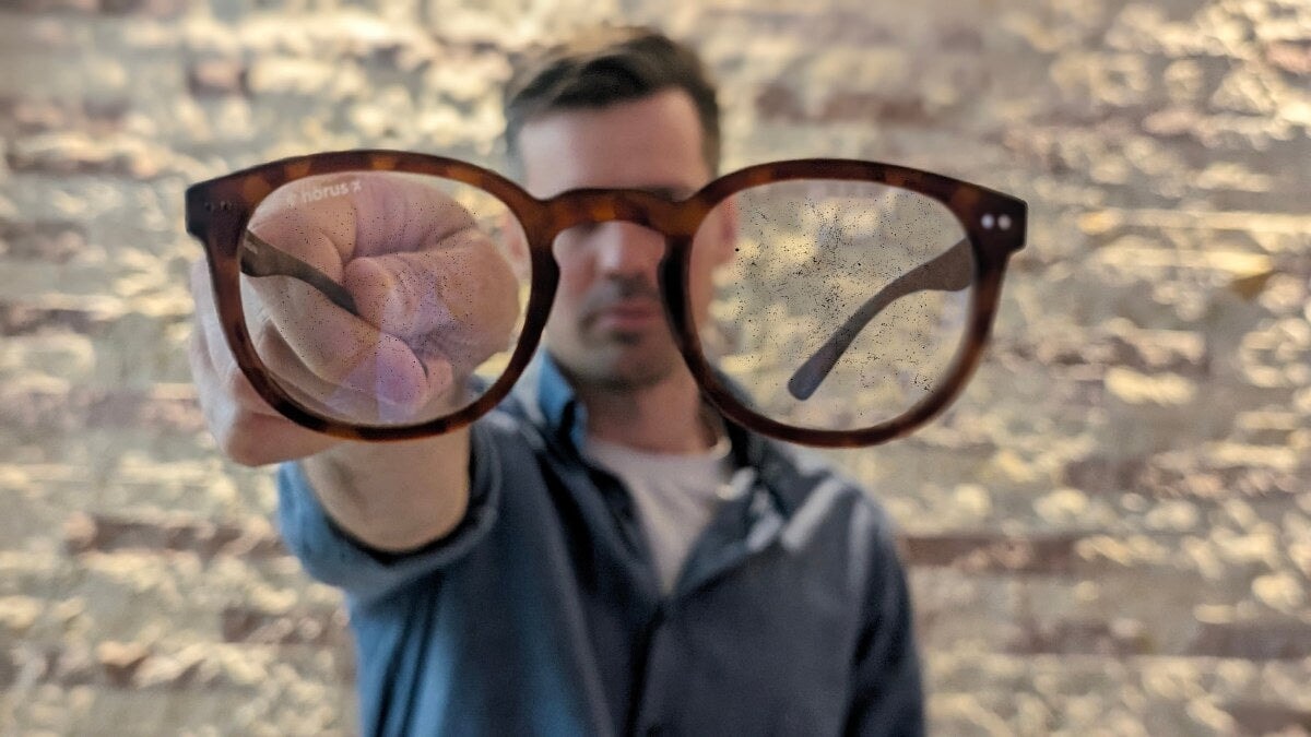 homme tenant des lunettes horus x