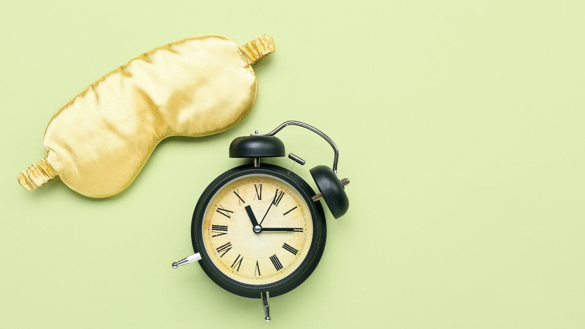 un masque de sommeil et une horloge sur une table