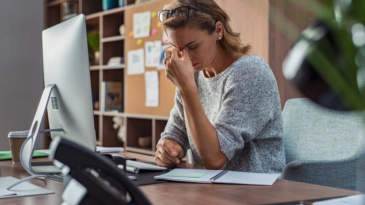 une femme ayant des maux de tête au bureau