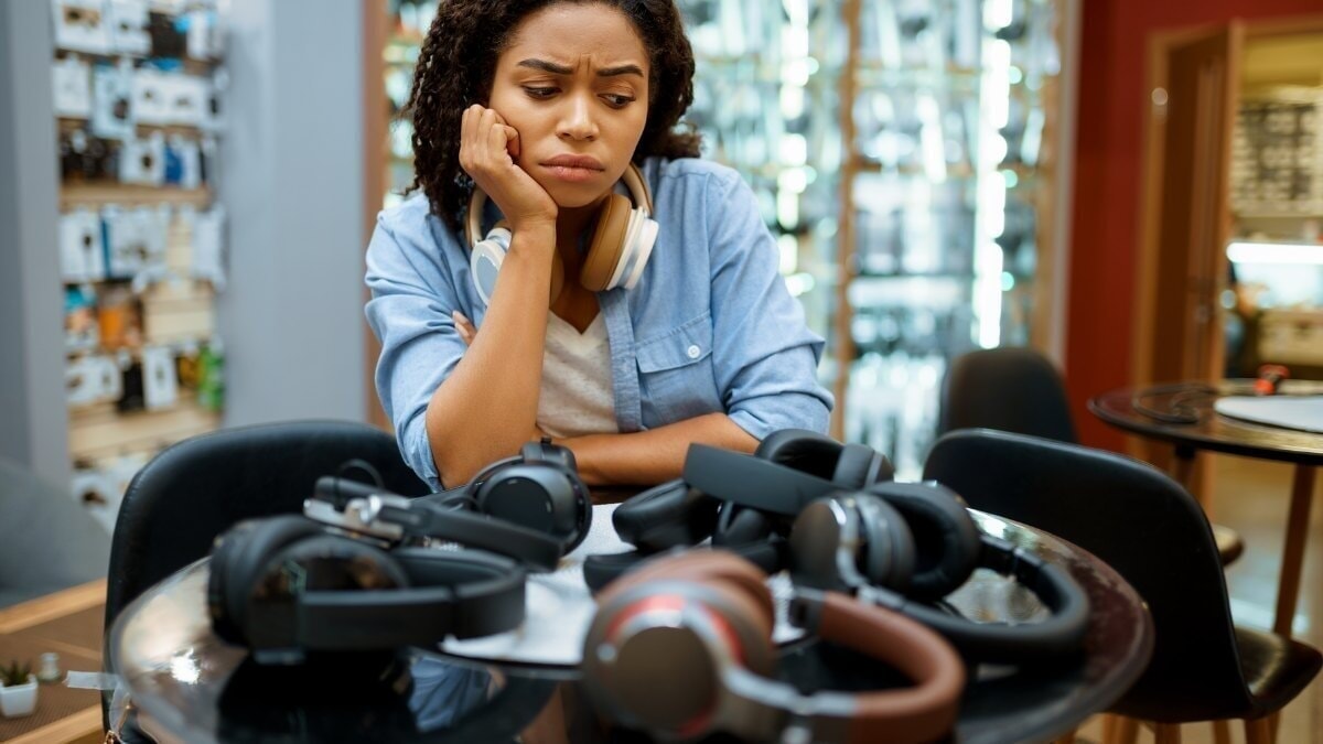 une femme choisissant des écouteurs dans un magasin de systèmes de haut-parleurs
