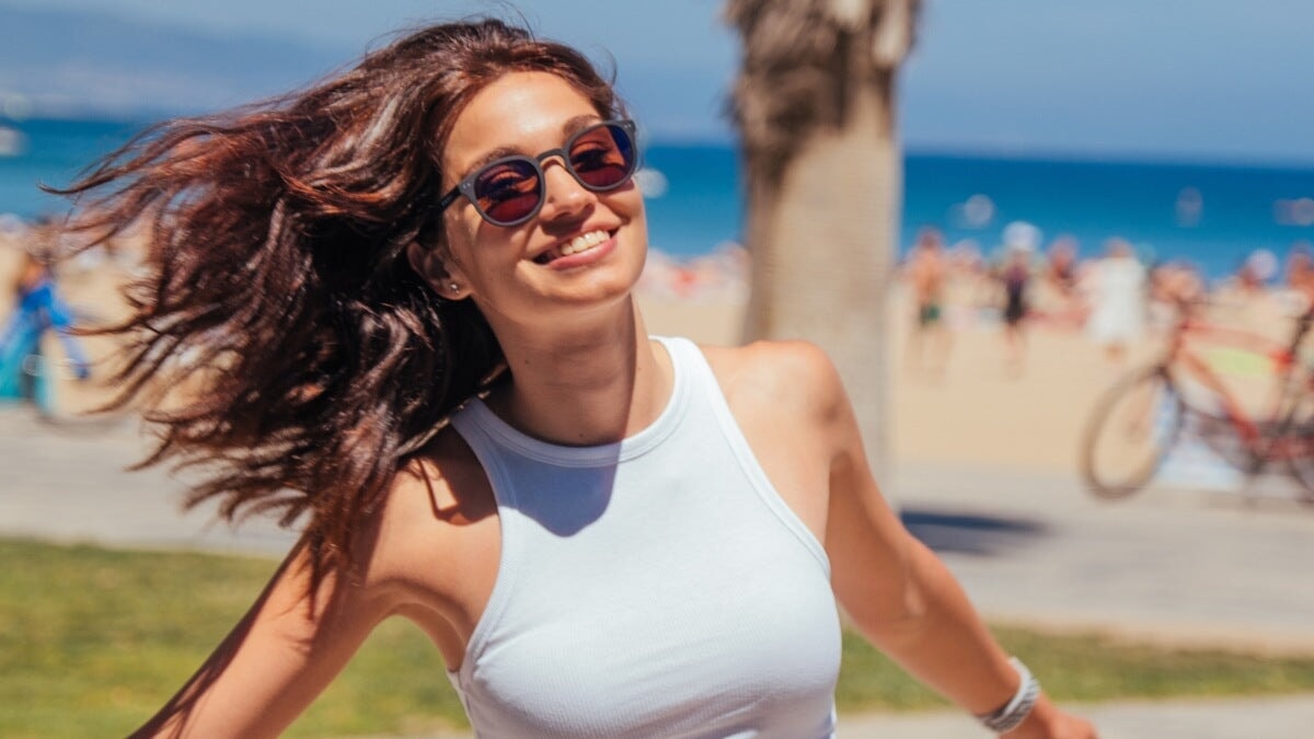 une femme portant des lunettes de soleil horus x sur la plage
