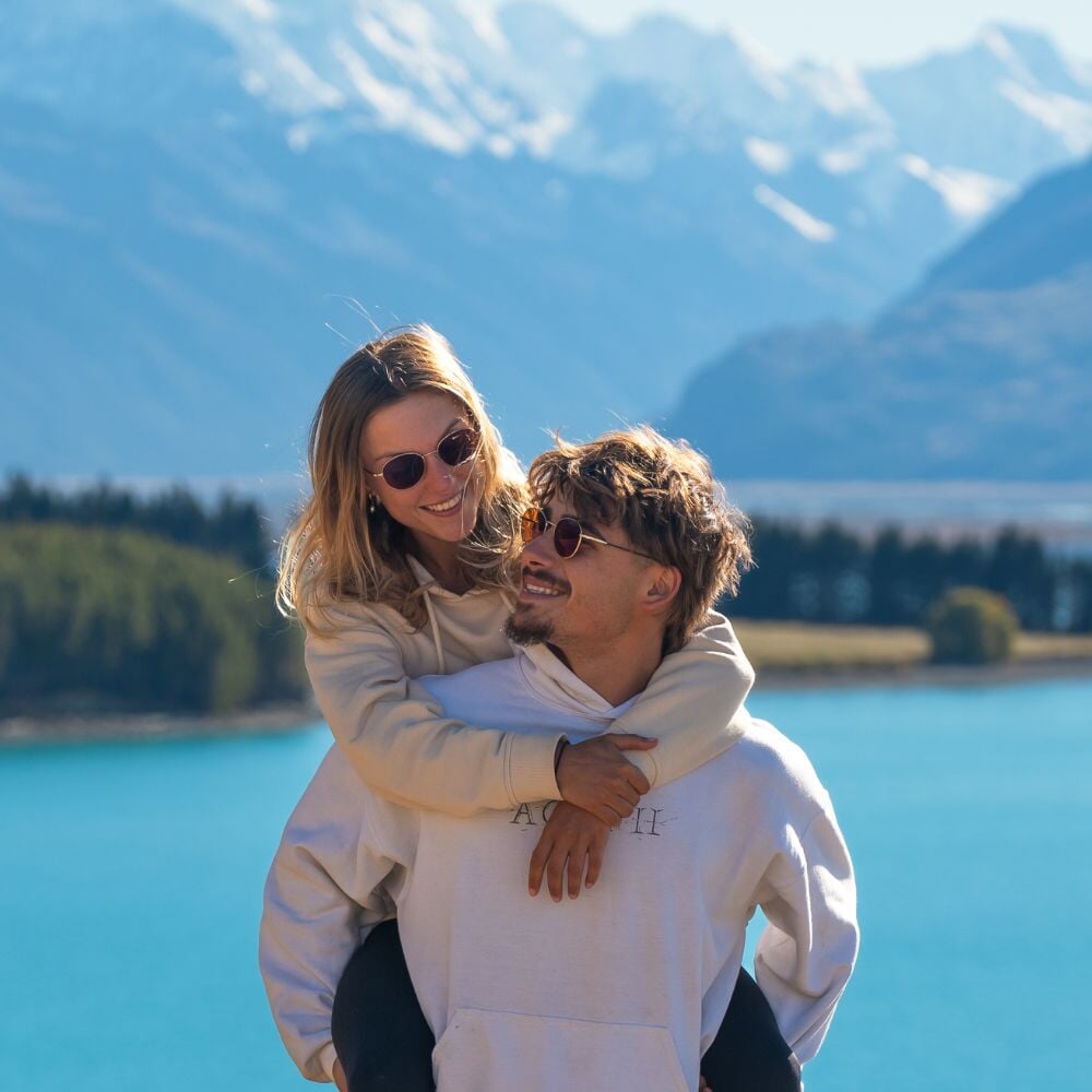 Les Expats portent les lunettes de soleil Ushuaia gold polarisées en nouvelle zélande, devant un lac et des montagnes